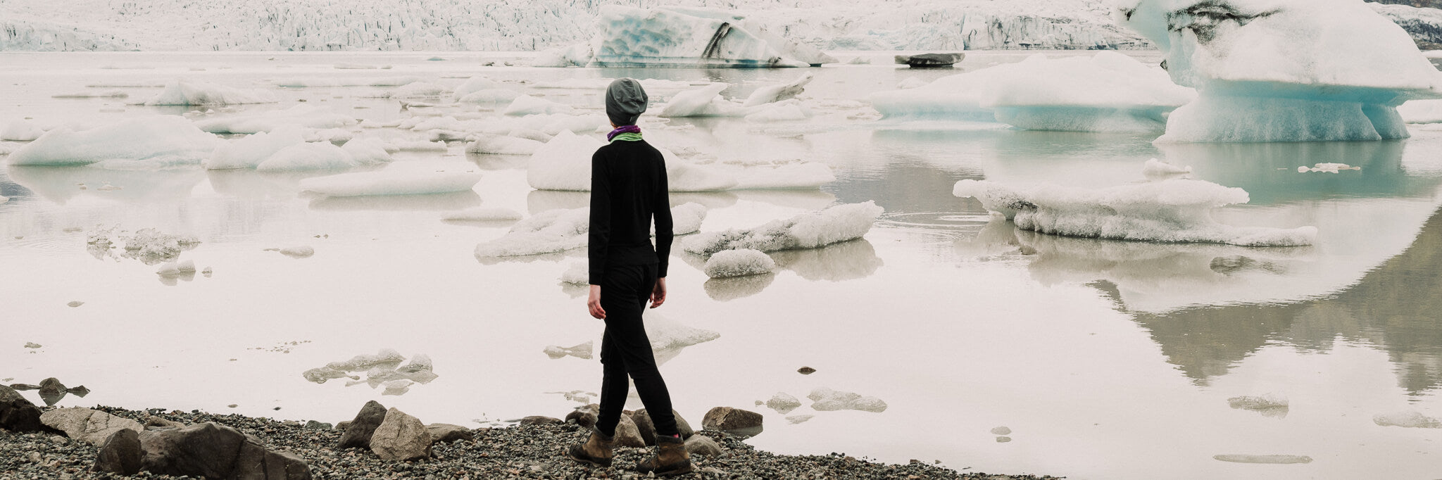 A-woman-with-thermal-shirt-and-pants-walking-near-the-lake-with-icebergs
