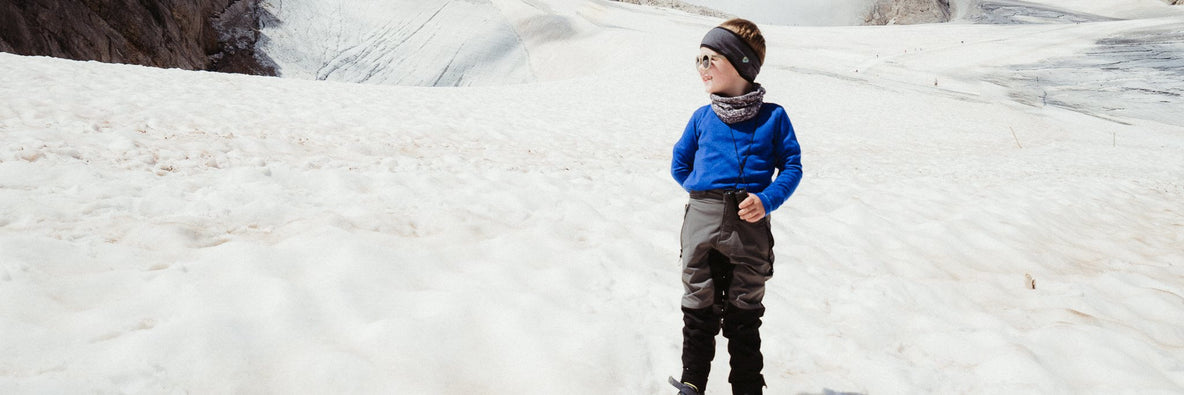 Kid is wearing a blue thermoshirt in the mountains