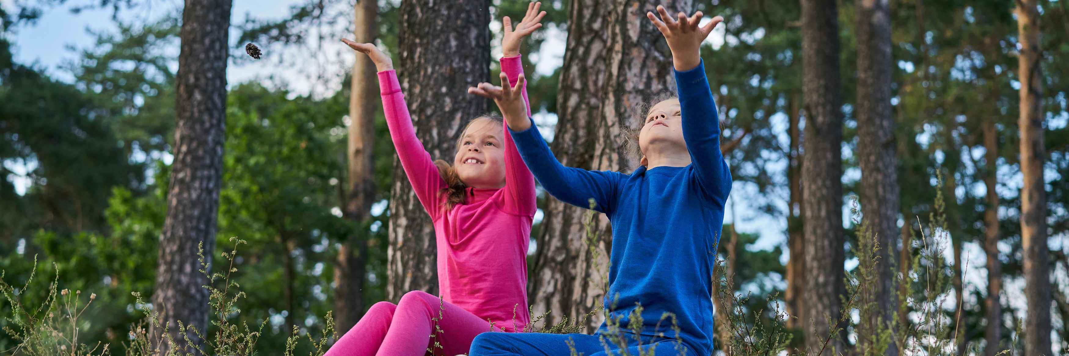 A girl and boy are wearing colorful thermo clothes on the grounds and enjoying nature