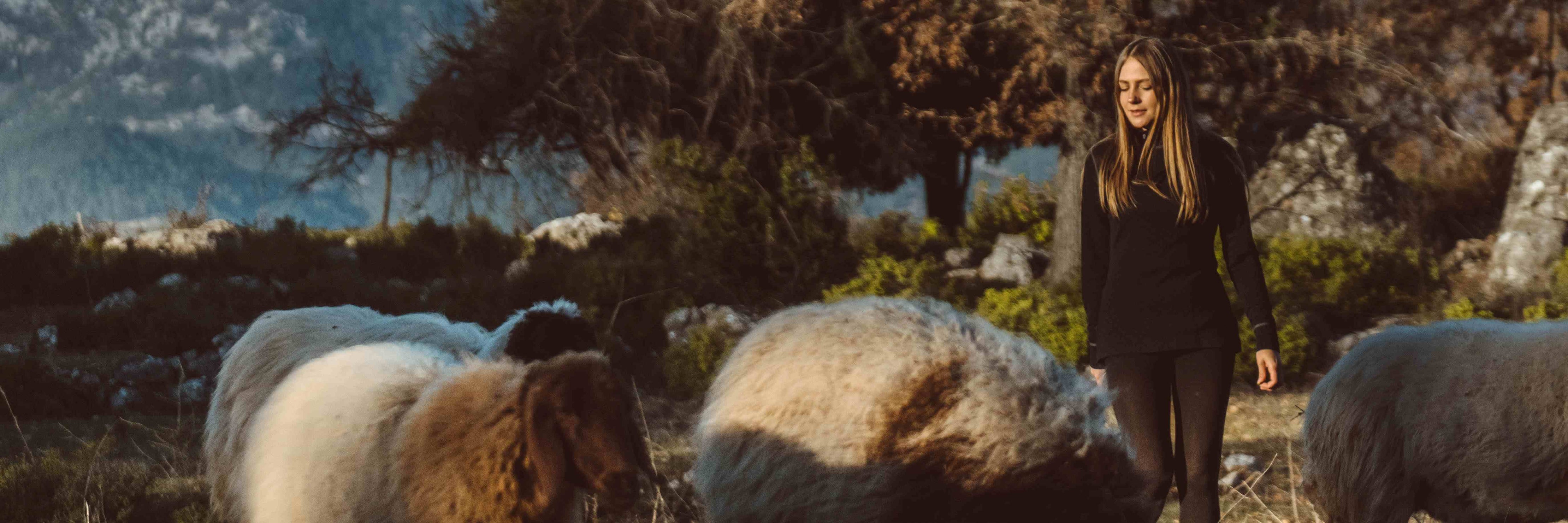 woman-walks-with-sheeps-in-the-fields