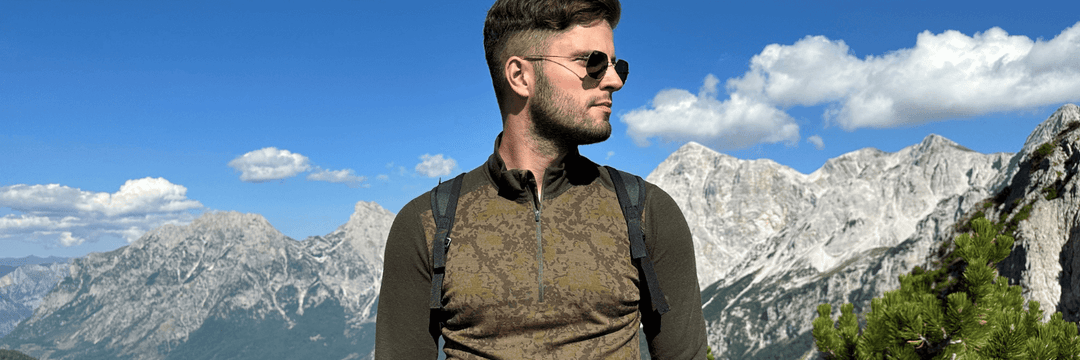 A man standing, surrounded by mountains