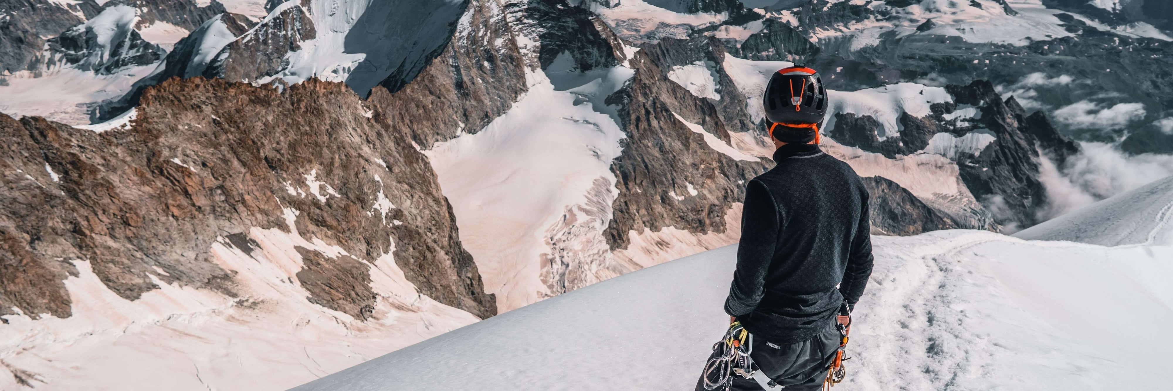 a-man-in-snowy-mountains-with-thermal-shirt-and-climbing-equipment