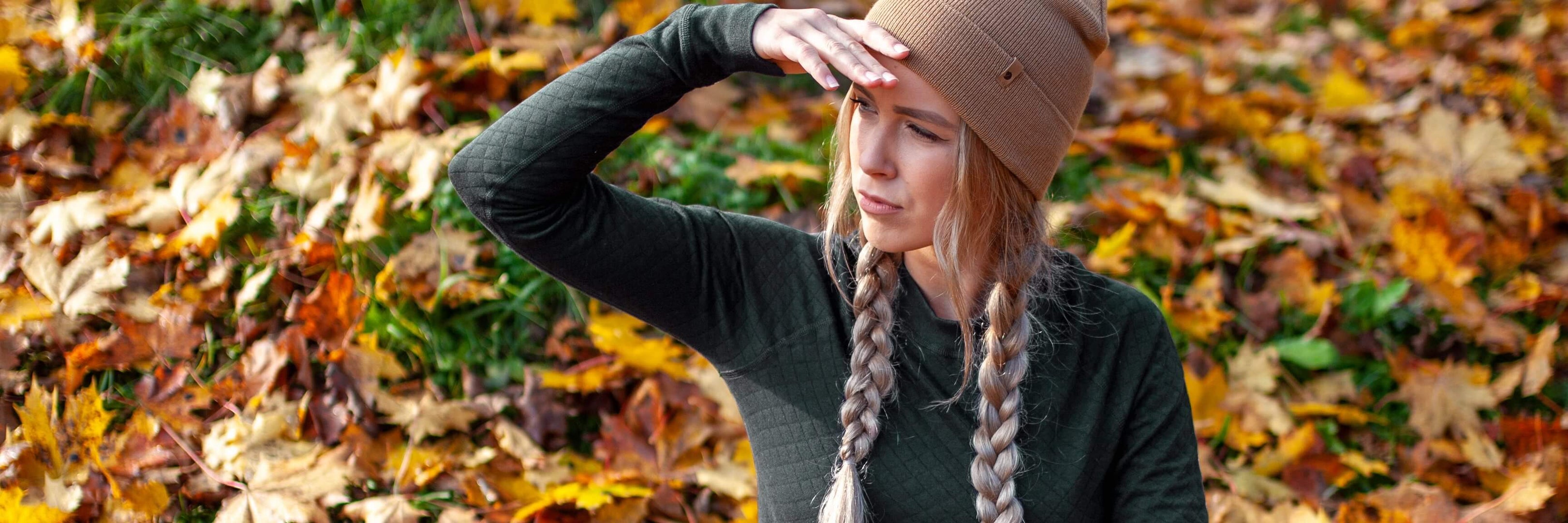 a-woman-in-thermal-clothing-sits-on-a-ground-among-fallen-leaves-in-autumn