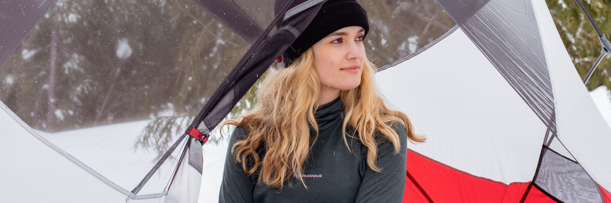 happy-woman-sits-in-her-tent-at-winter-with-thermal-shirt-and-a-hat