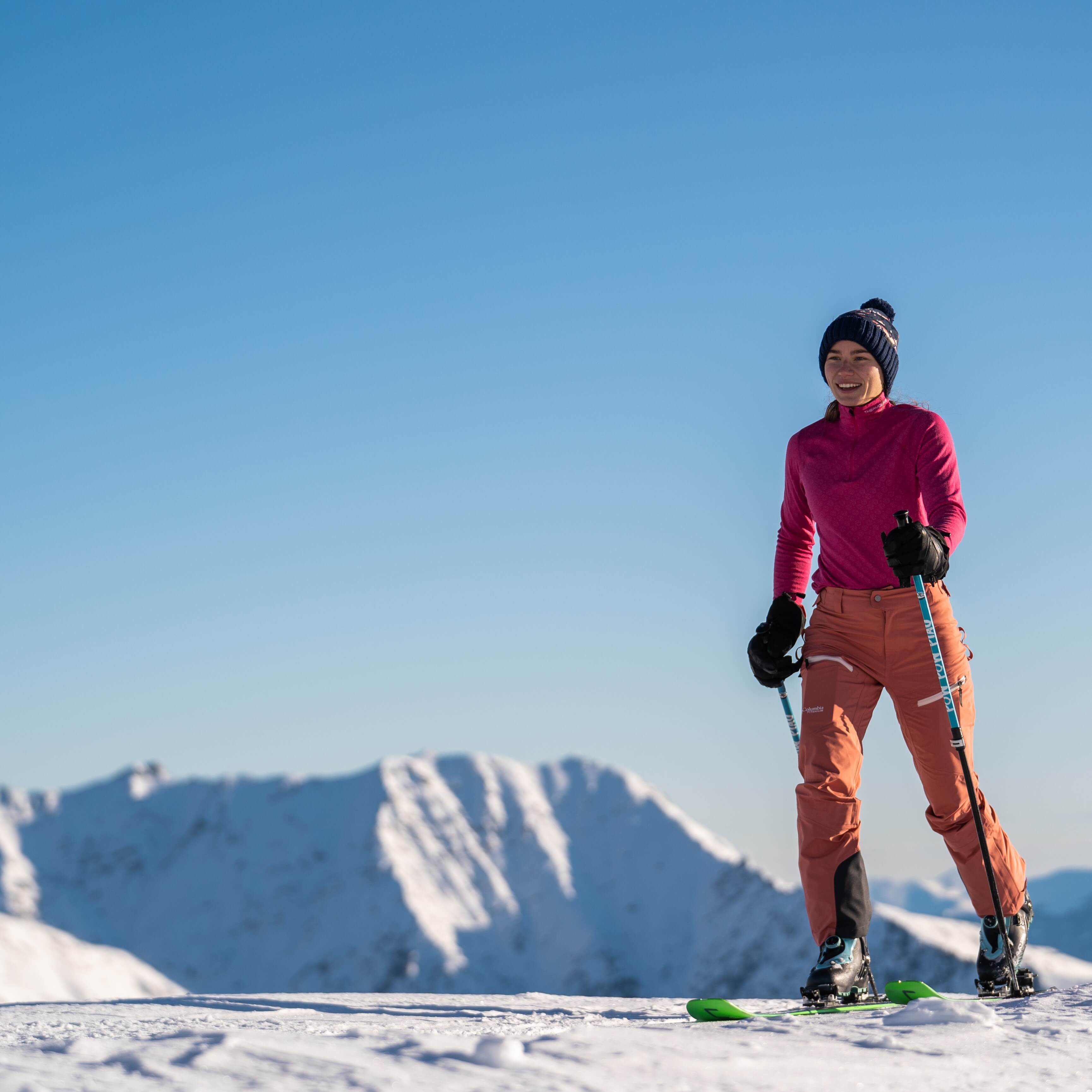 happy-woman-with-pink-thermal-shirt-skiing-in-the-mountains
